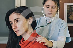 Young female physician performs a medical examination on a middle-aged patient