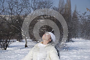 Young female playing with snow in winter