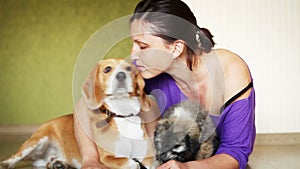 Young female plays with two lovely dogs on the home laminate floor