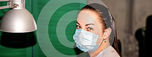 Young female podiatrist with a protective mask looking at the camera in her podiatry clinic.