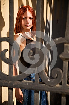 Young female posing in behind of grate