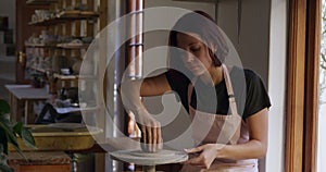 Young female potter working in her studio