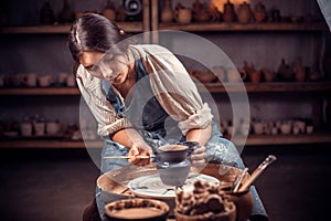 Young female potter working on a potter& x27;s wheel.