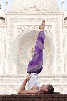 Young female practising yoga asana Sarvangasana at Taj Mahal