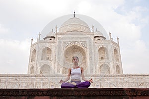 Young female practising yoga meditation at Taj Mahal