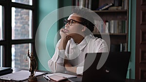 Young female professional lawyer working with laptop and resting, sitting at table in company spbas.