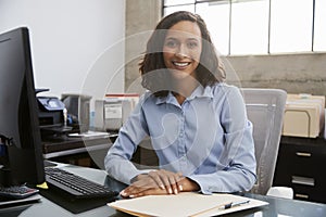 Young female professional sitting at desk in an office