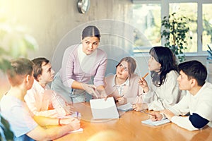 Young female professor explaining subject to group of students