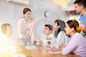 Young female professor explaining subject to group of students