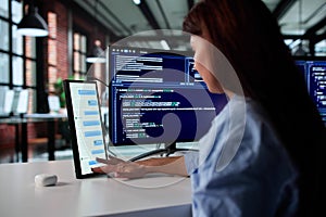 Young Female Programmer Multitasking On Multiple Screens