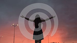 Young female raising hands up looking at sunrise, morning nature, freedom peace