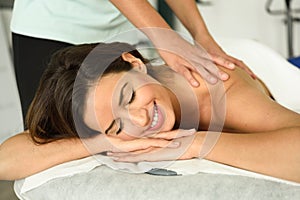 Young female receiving a relaxing back massage in a spa center.