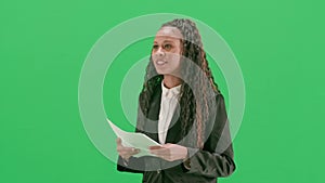 Young female reporter isolated on chroma key green screen background. African american woman tv news host walking