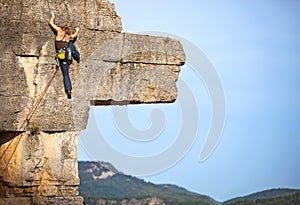 Young female rock climber on a cliff