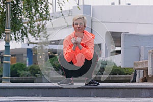 Young female runner preparing for jogging in the city street. Fit body requires hard work. Urban sport concept. Young female