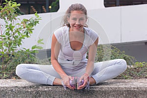 Young female runner preparing for jogging in the city street. Fit body requires hard work. Urban sport concept. Young female