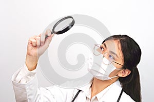 Young female scientist or doctor looking something through a magnifying glass. Research and invent concept