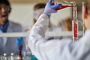 A young female scientist doing an experiment at the university laboratory. Science, chemistry, lab, people