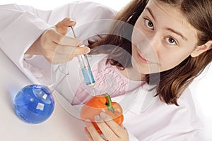 Young female scientist injecting an orange pepper