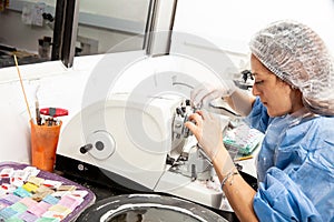 Young female scientist works on a rotary microtome to obtain sections from a paraffin-embedded specimen photo