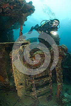 Young female SCUBA Diver explores shipwreck