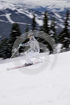 A young female skier enjoying downhill skiing in British Columbia mountains