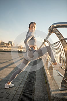 Young female sportsperson stretching her legs and doing lunges