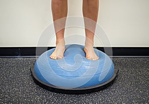 Young female standing on a bosu ball for a workout