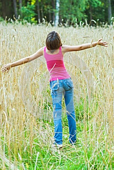 Young female stands in crop field