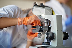 A young female student adjusts a microscope in a laboratory. Science, chemistry, lab, people