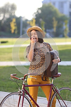 Young female student with backpack and books riding a retro bicycle.Female on retro bicycle.