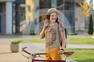 Young female student with backpack and books riding a retro bicycle.Female on retro bicycle.