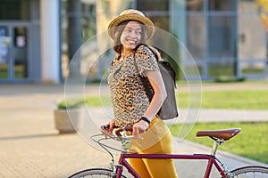 Young female student with backpack and books riding a retro bicycle.Female on retro bicycle.