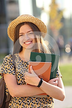 Young female student with backpack and books.