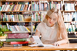 Young female student doing assignments in library photo