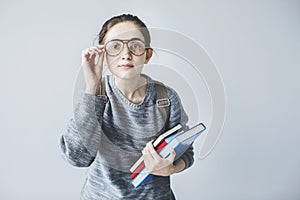 Young female student looking carefully and holding books