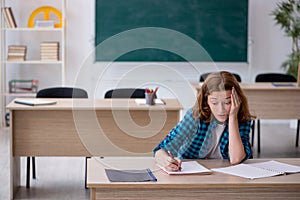 Young female student preparing for exam in the classroom