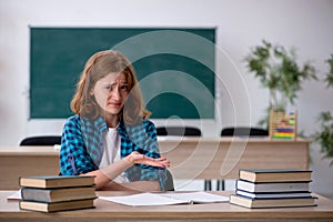 Young female student preparing for exam in the classroom