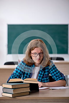 Young female student preparing for exam in the classroom