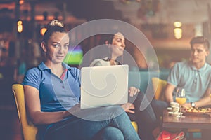 Young female student is using laptop computer in cafe