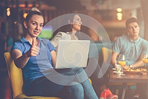 Young female student is using laptop computer in cafe