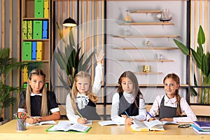 Young female students in school uniforms before the lesson in the classroom.