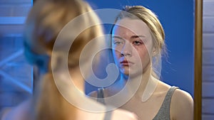 Young female suffering depression, crying looking at mirror reflection, despair photo