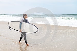 Young female surfer wearing wetsuit