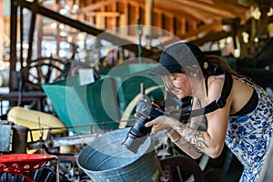 Young female taking pictures of vintage grindstone