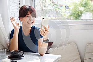 Young female talking with her friend on smartphone device. Copy