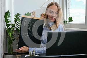 Young female teacher sitting at desk and using laptop at home. e Education Back to school. Student learning online class