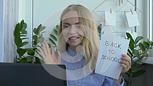 Young female teacher sitting at desk and using laptop at home. e Education Back to school. Student learning online class