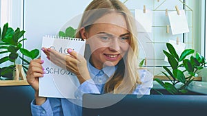 Young female teacher sitting at desk and using laptop at home. e Education Back to school. Student learning online class