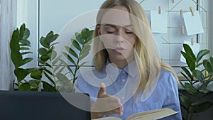 Young female teacher sitting at desk and using laptop at home. reading book e Education Back to school. Student learning